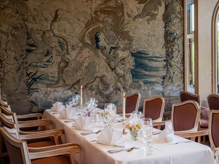festlich dekorierter Tisch mit Blumengestecken für eine Feier im Raum Gobelin