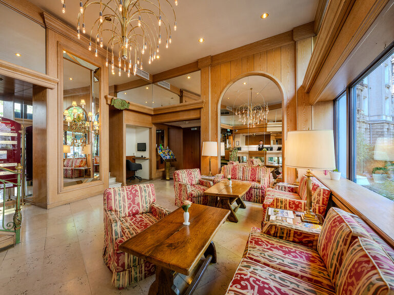 Lobby mit Sitzgruppen, verspiegelten Wänden und Rezeption im Ringhotel Seehof Berlin