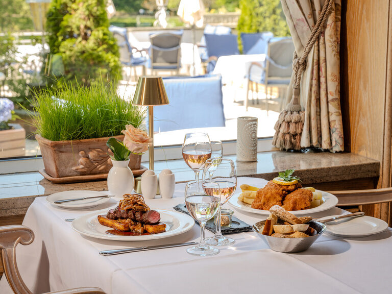 Elegant gedeckter Tisch mit schmackhafter Hauptspeise und Weingläsern im Ringhotel Seehof Berlin