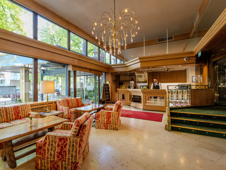 Rezeption und Lobby mit Sitzgruppen im Hotel Seehof Berlin mit Stufen ins Restaurant geradezu rechts