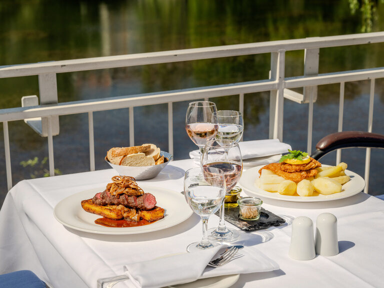 frische saisonale und regionale Küche - bei schönem Wetter auf der Terrasse zwei Gerichte - 1 Teller mit Zwiebelrostbraten und 1 Teller mit Kalbsschnitzel und Spargel
