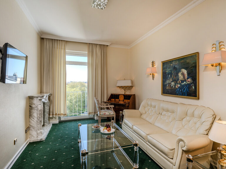 Wohnzimmer in der Suite mit Schlafcouch, Couchtisch, Sekretär und Blick auf den Funkturm und den Lietzensee